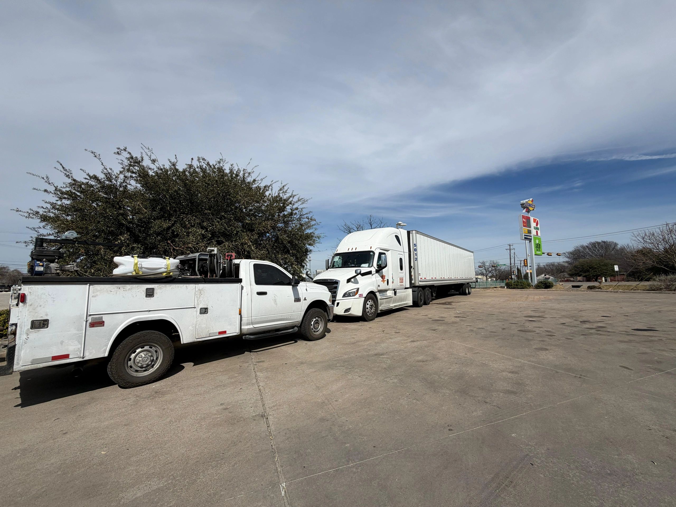 Waco Road Service truck parked in front of a semi truck and trailer to provide roadside assistance.