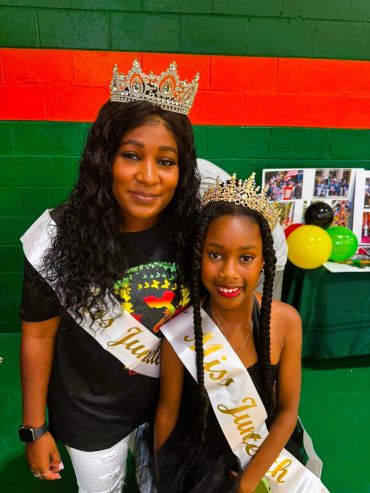 Two crowned women with sashes at a festive event.