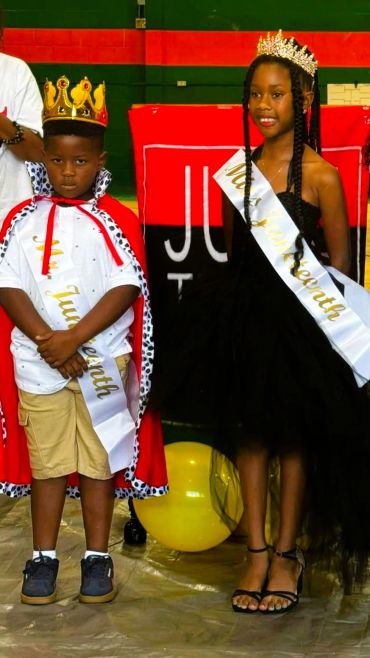 Two children crowned and wearing sashes for a pageant.