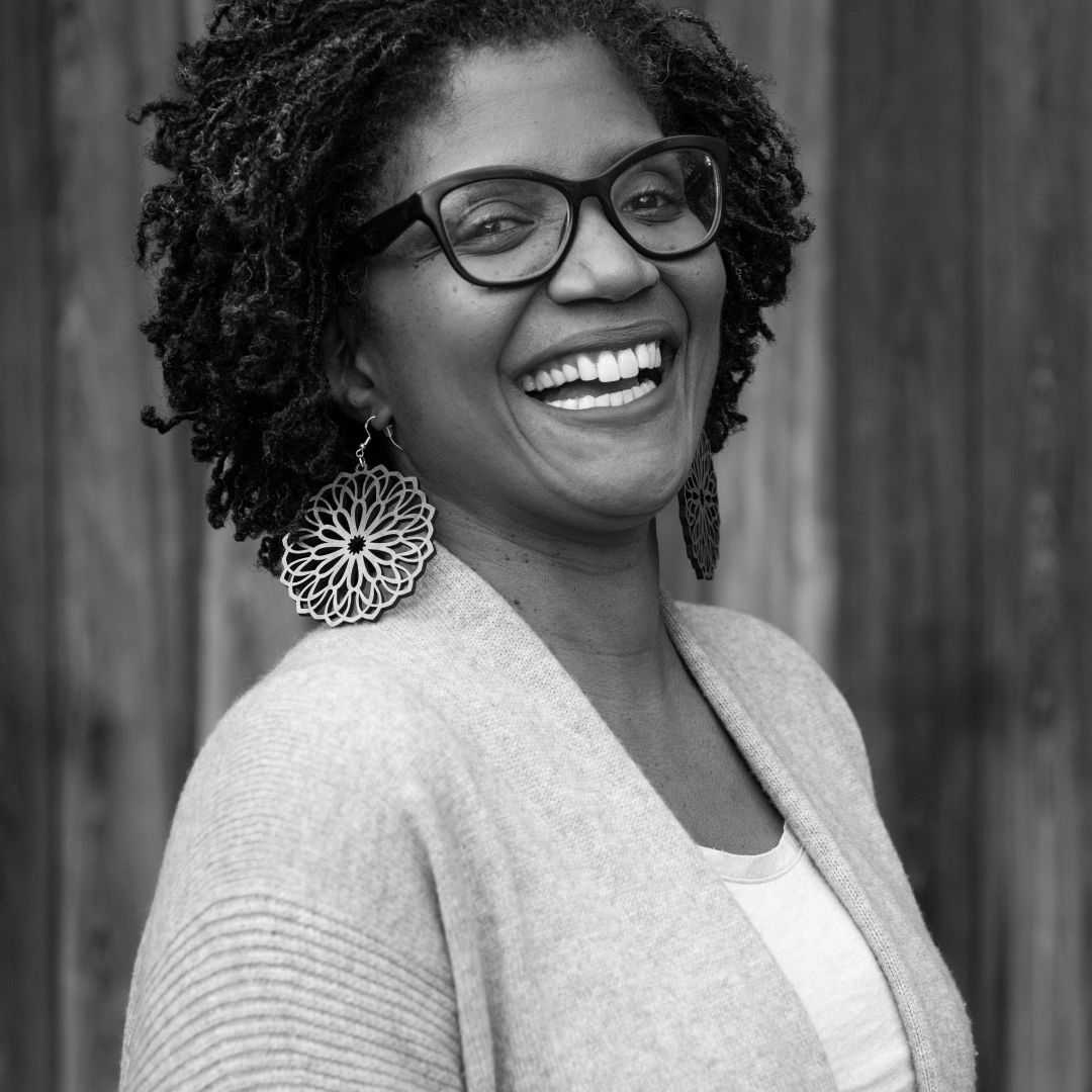 Woman smiling, wearing mandala style earrings.