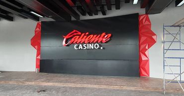 Entrance sign of Caliente Casino with red and black design.