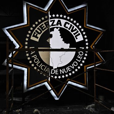 Illuminated sign of Fuerza Civil police in Nuevo León at night.