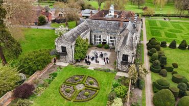Aerial view of an old manor with formal gardens.