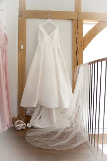 Elegant white wedding dress hanging with veil.