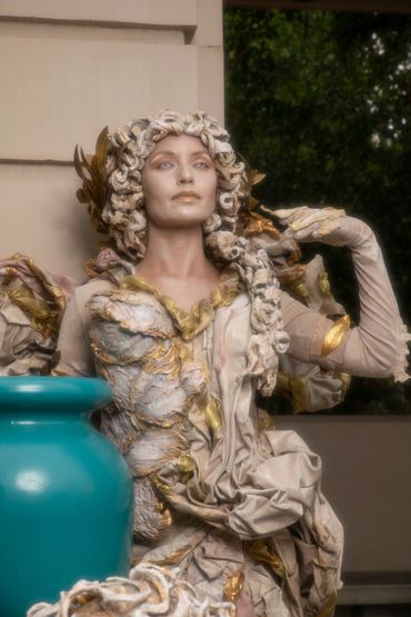 A Sculpture Of A Woman With A Blue Color Pot.