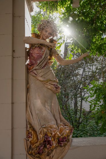 A Marble SculptureOf A Woman Standing On A Wall.