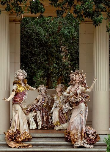 Statues in front of foliage
