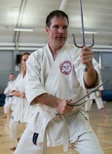 Martial artist practicing with sai weapons.