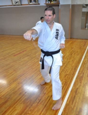 Man practicing karate in a dojo.