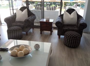 Cozy living room with two armchairs and patterned ottomans.