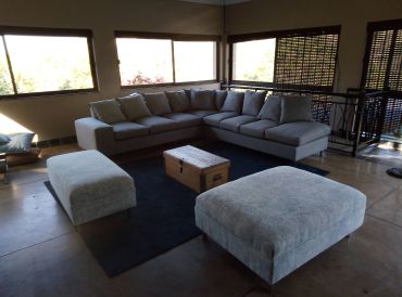 Modern living room with a large gray sectional sofa and matching ottomans.