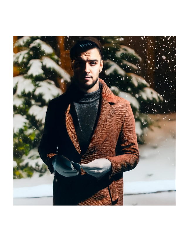 Owner, Jose, professional photo during winter wearing a brown coat, snow covered trees in background