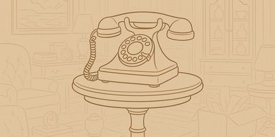 Vintage rotary phone on a round wooden table in a cozy room.