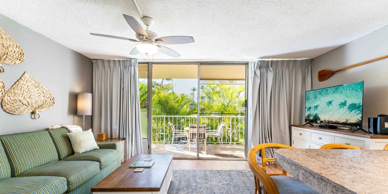 Cozy living room with tropical decor and balcony seating.