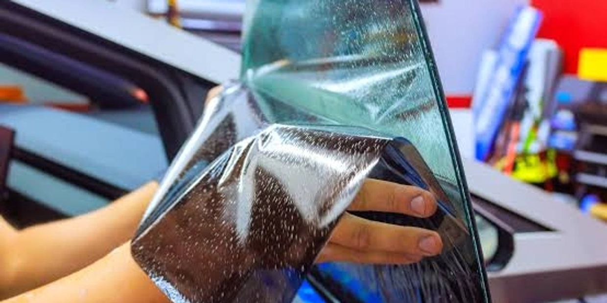 Applying window tint film on a car window.