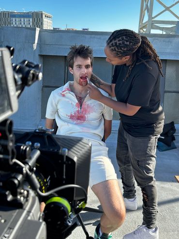Man strapped to a chair with a woman holding a dental tool in his mouth with blood coming his mouth