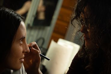 Photo of a woman doing another woman's makeup 