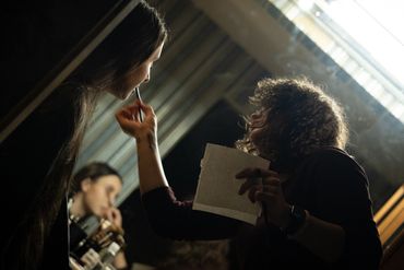 A dynamic photo of a woman doing another woman's makeup 