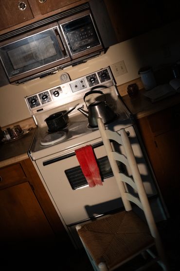 A dramatic photo of a chair in front of an oven
