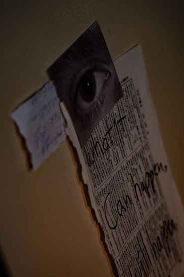 A photo of papers and a picture of a human eye hanging on a fridge