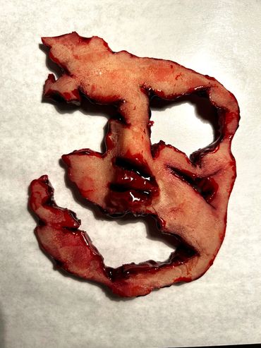 Human face made of gelatin that has been cut & painted to look like it has been cut off the face 