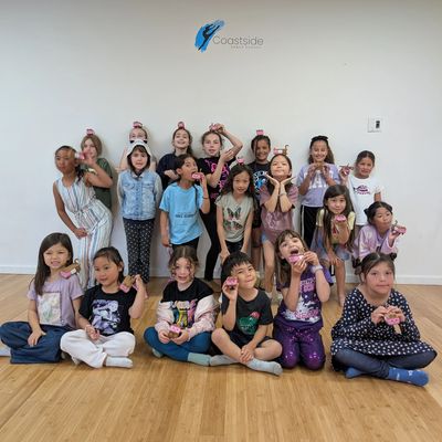 Group of children posing happily indoors with small toys.