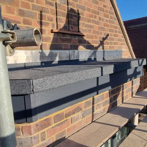 Shadow on brick wall looks like a person with raised hands.