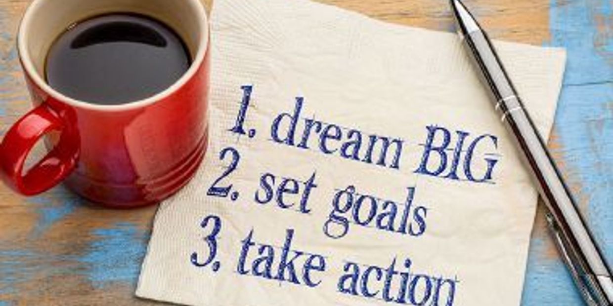 Coffee mug next to a motivational note and pen.