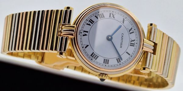 Elegant gold Cartier wristwatch with Roman numerals and a sleek design.