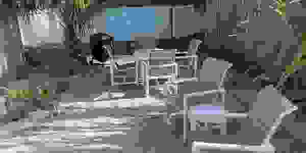 Cottage B - Private Patio with Grill, Table, Chairs, and Umbrella.