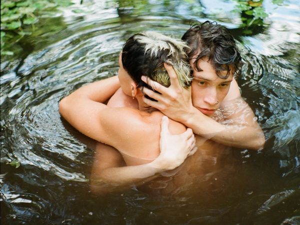 Two people embracing tenderly in a body of water.