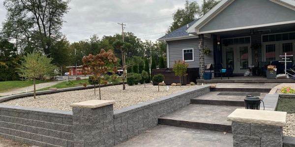 Back of house with decorative stamped steps and retaining wall