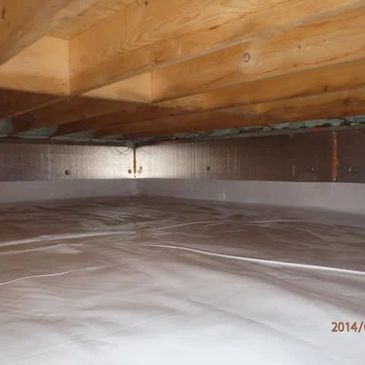 Clean crawl space with plastic vapor barrier and wooden joists overhead.