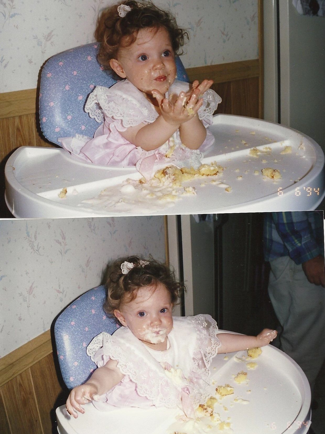 A baby in a pink dress enjoying and making a mess with cake in a high chair.