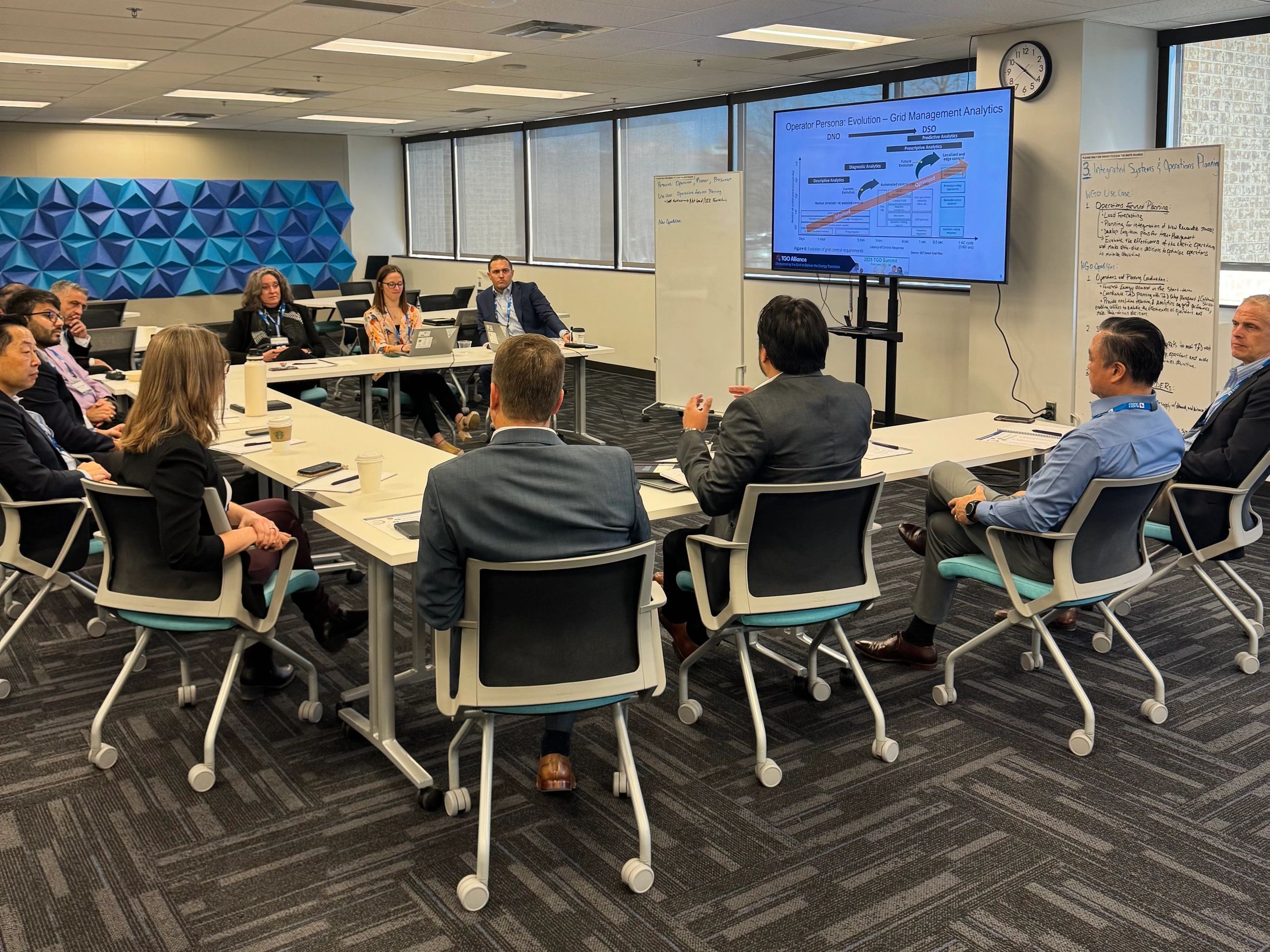 A business meeting discussing grid management analytics in a modern conference room.