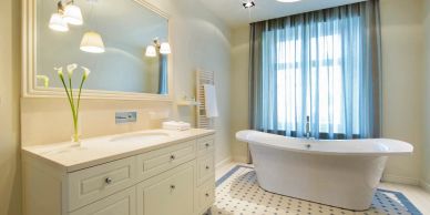 Bright bathroom with white bathtub and vanity.