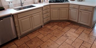 Kitchen with beige cabinets and tiled floor.