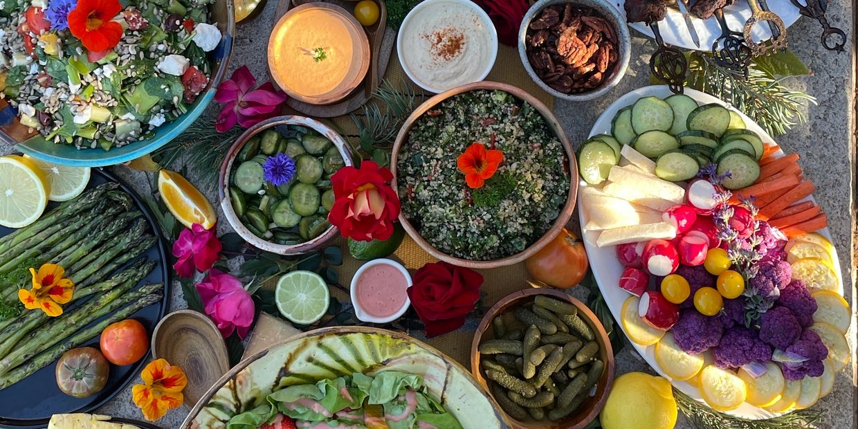 Colorful fresh vegetable and salad spread with flowers.