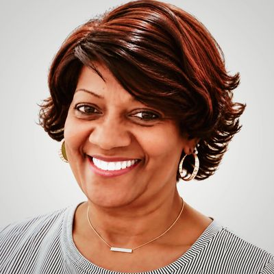 Smiling woman with short hair and hoop earrings.