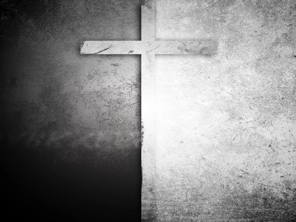 A cross casting a shadow on a textured black and white background.
