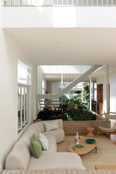 Modern living room with curved sofa and indoor plants.