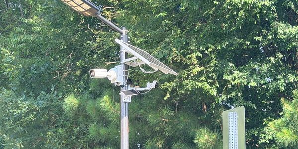 Solar-powered security camera mounted on a pole.
