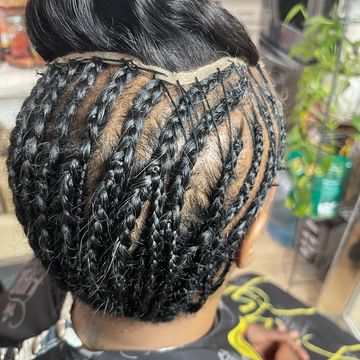 Intricate braided hairstyle with neat, geometric patterns and a bun.