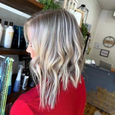 Wavy blonde hair with silver highlights.