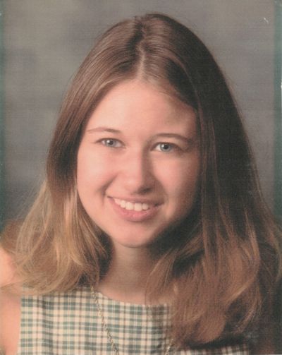 Portrait of a young woman with long hair smiling.