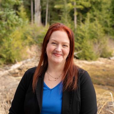 Smiling woman with red hair outdoors.