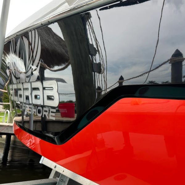 Close-up of a black and orange boat with 'TARAB OFFSHORE' logo.
