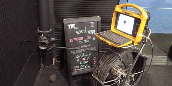 A bicycle integrated with a computer and a restaurant sign in the background.