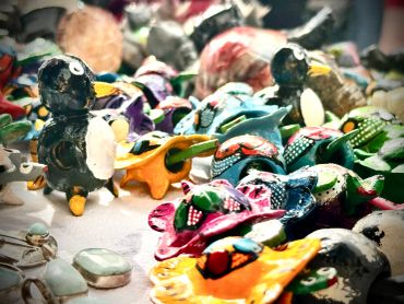 Colorful handcrafted animal figurines displayed on a table.