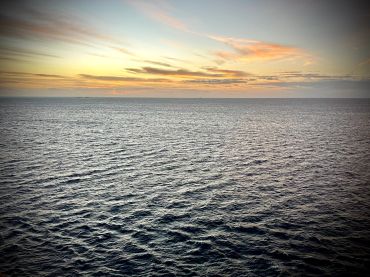 Calm ocean waters under a colorful sunset sky.